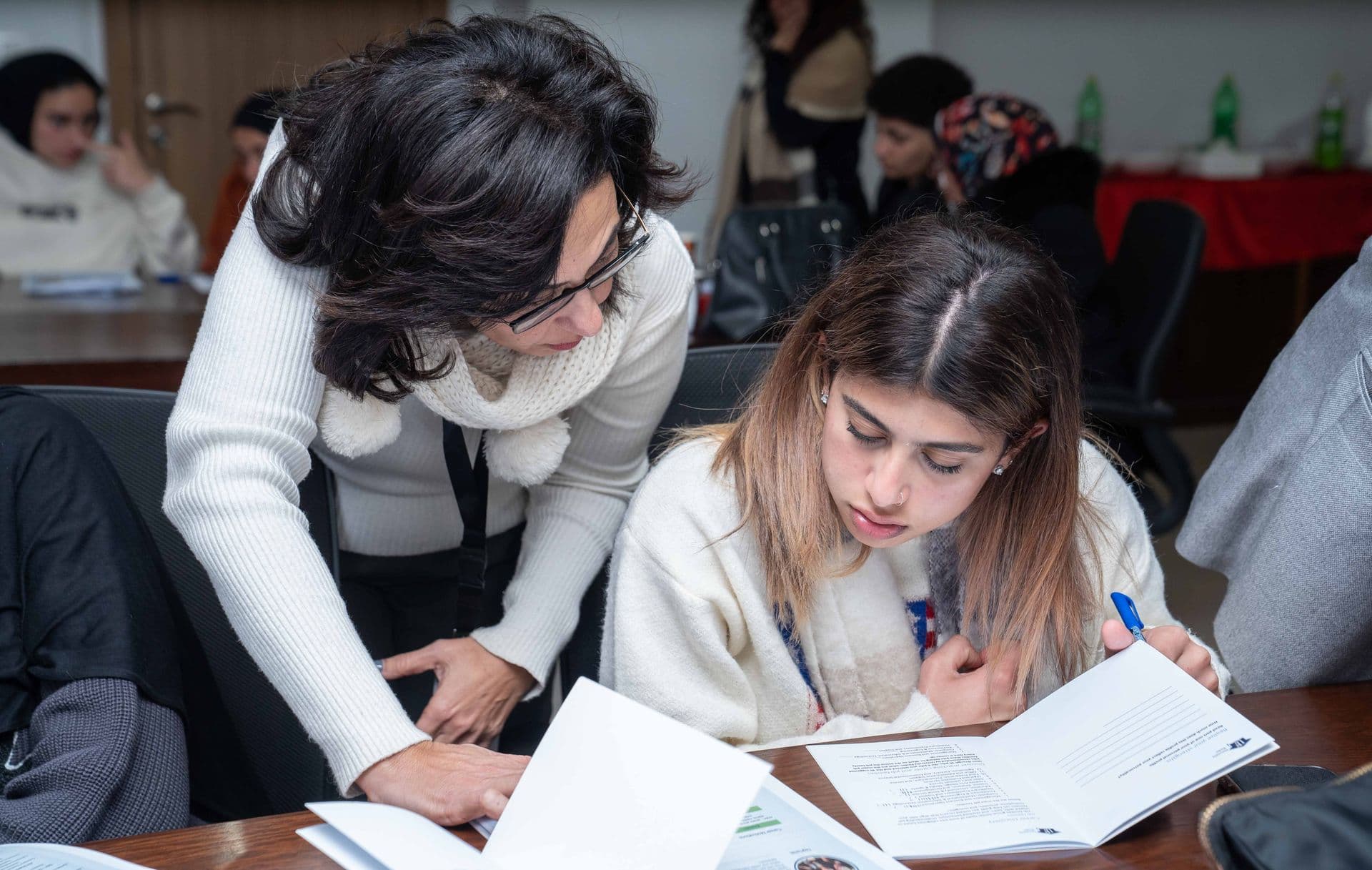 Pathfinder advisor working with a student over a guidance booklet